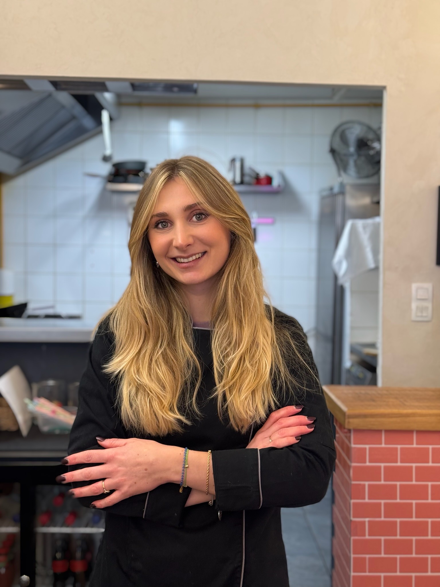 good-vibes cheffe margaux devant sa cuisine les bras croisées